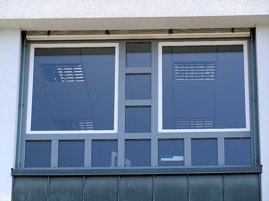Zweifarbige Kunststofffenster mit anthrazitfarbenem Rahmen und weißen Fensterflügeln